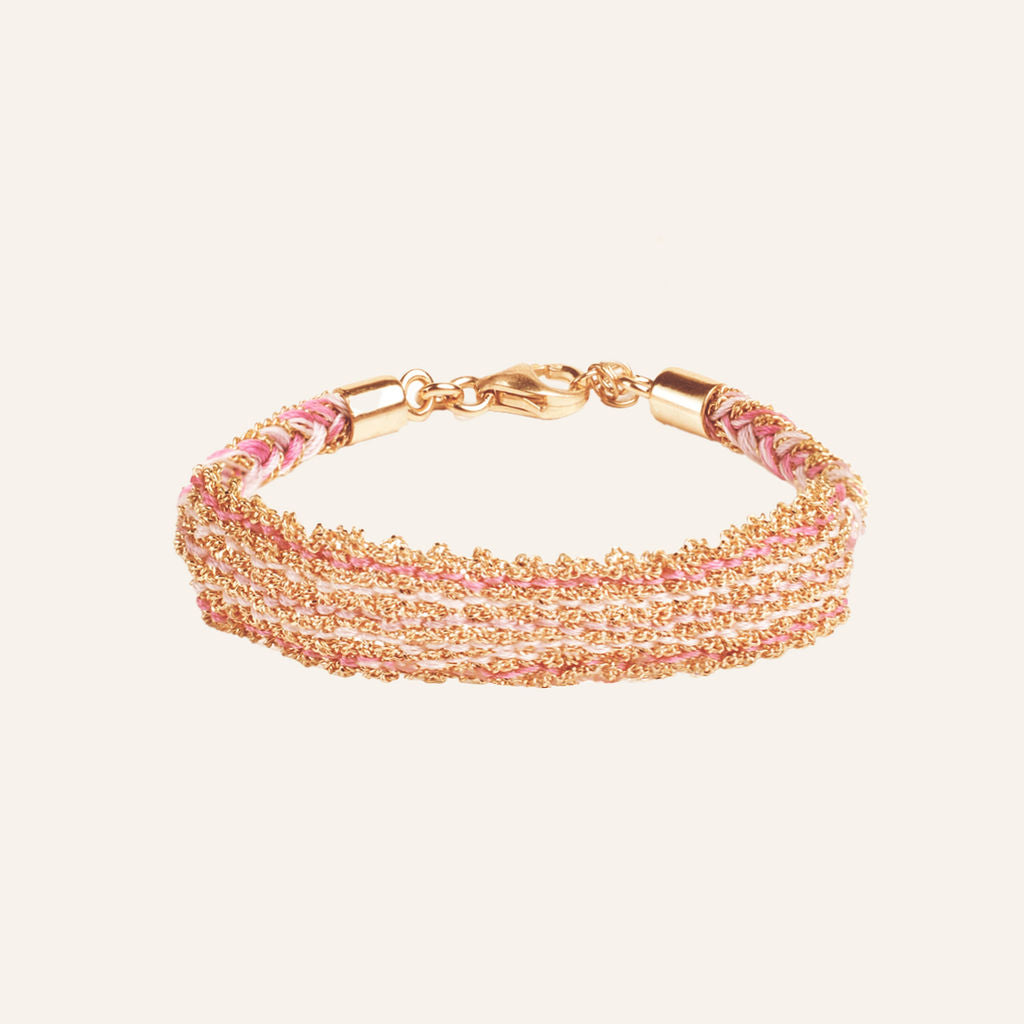 Detalhe de pulseira entrançada dupla cor com acabamento dourado brilhante